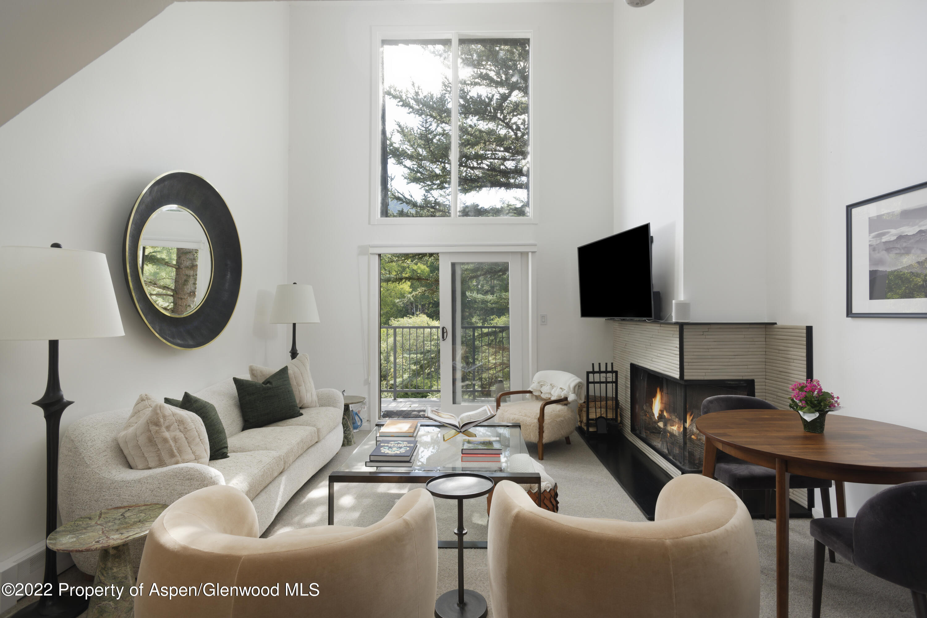 a living room with furniture a flat screen tv and a window