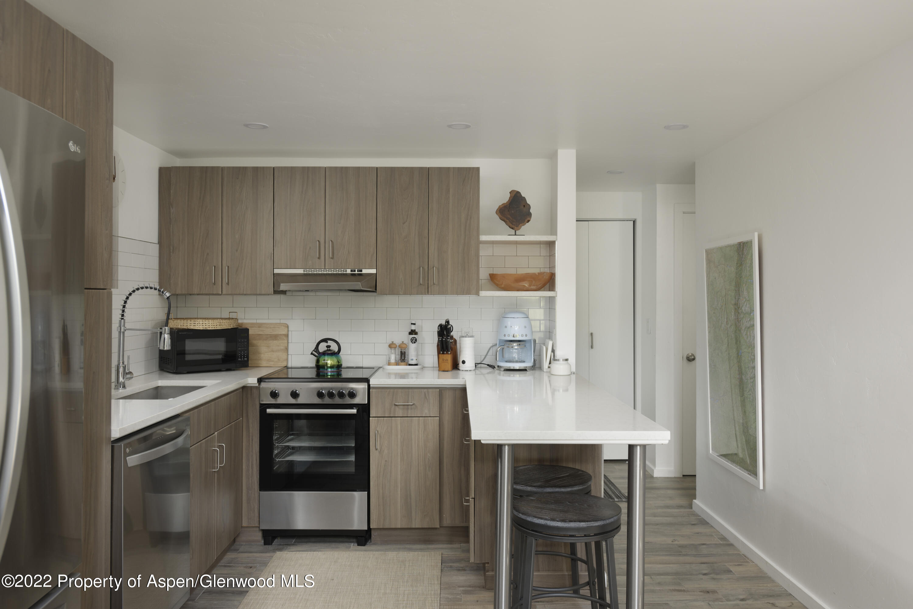 1050 Waters Avenue, Unit 14 Aspen, CO 81611 - Photo 5 of 19 a kitchen with a stove a sink and a refrigerator