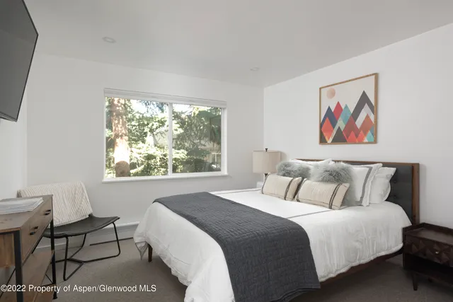 a bedroom with a bed and a painting on the wall