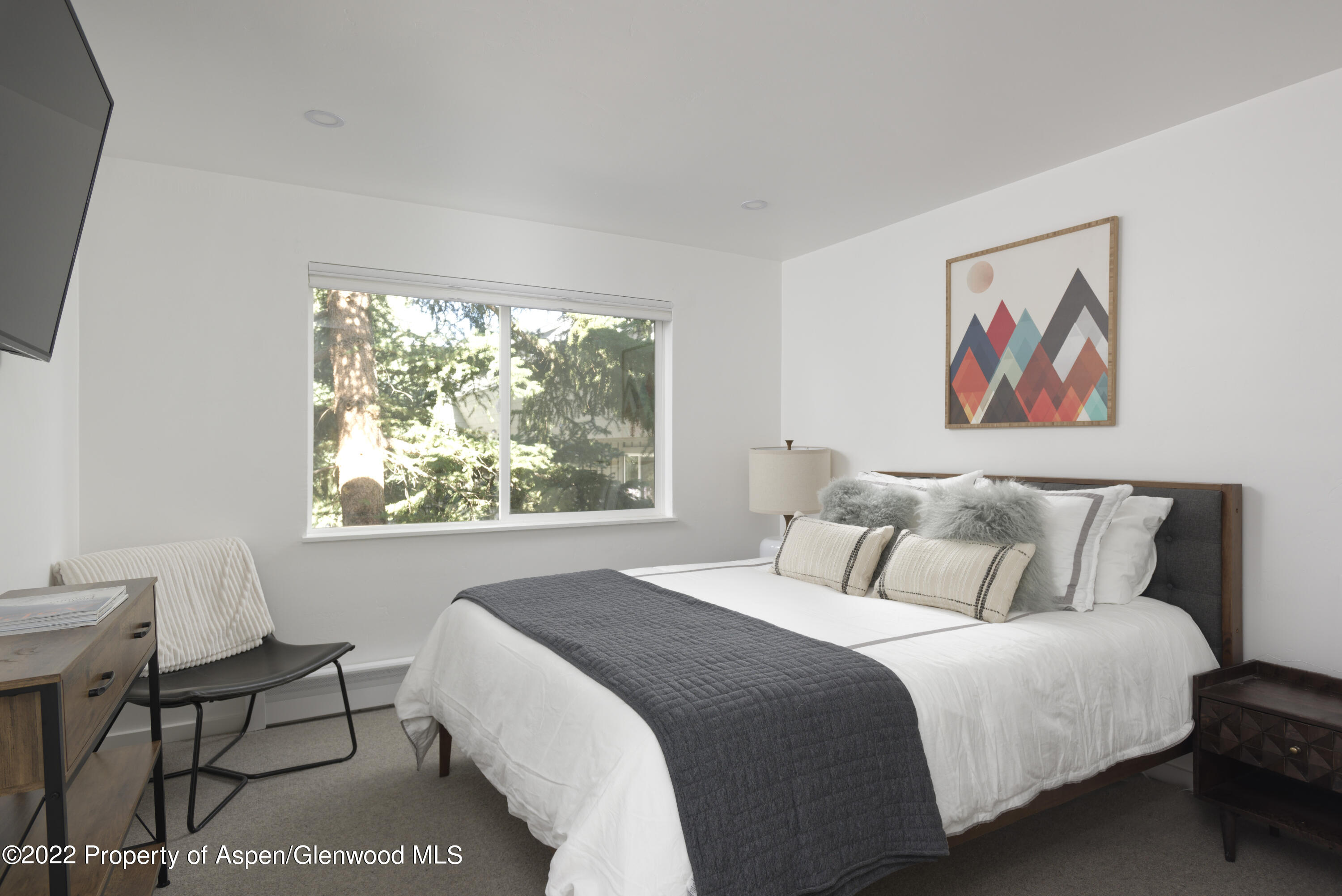 1050 Waters Avenue, Unit 14 Aspen, CO 81611 - Photo 8 of 19 a bedroom with a bed and a painting on the wall