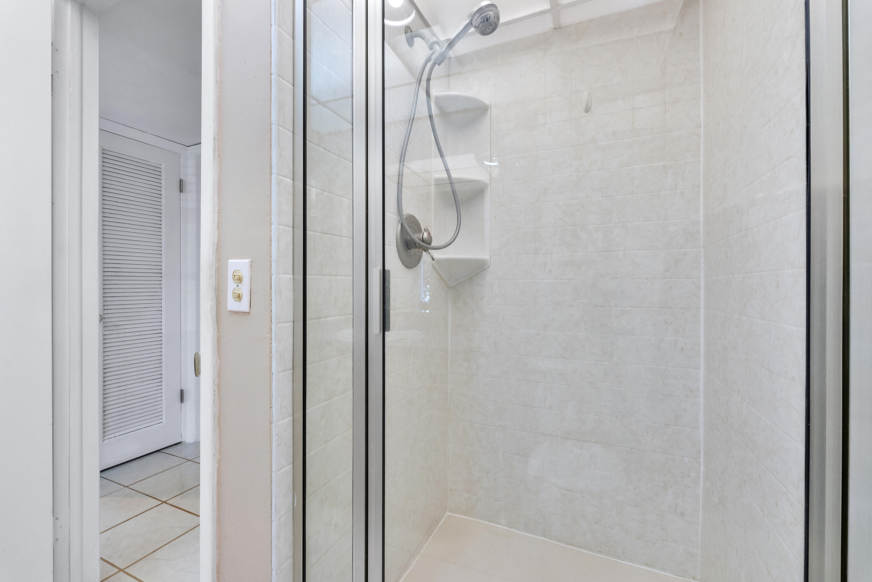 157 Flanders C Delray Beach, FL 33484 - Photo 17 of 45 a bathroom with a glass shower door