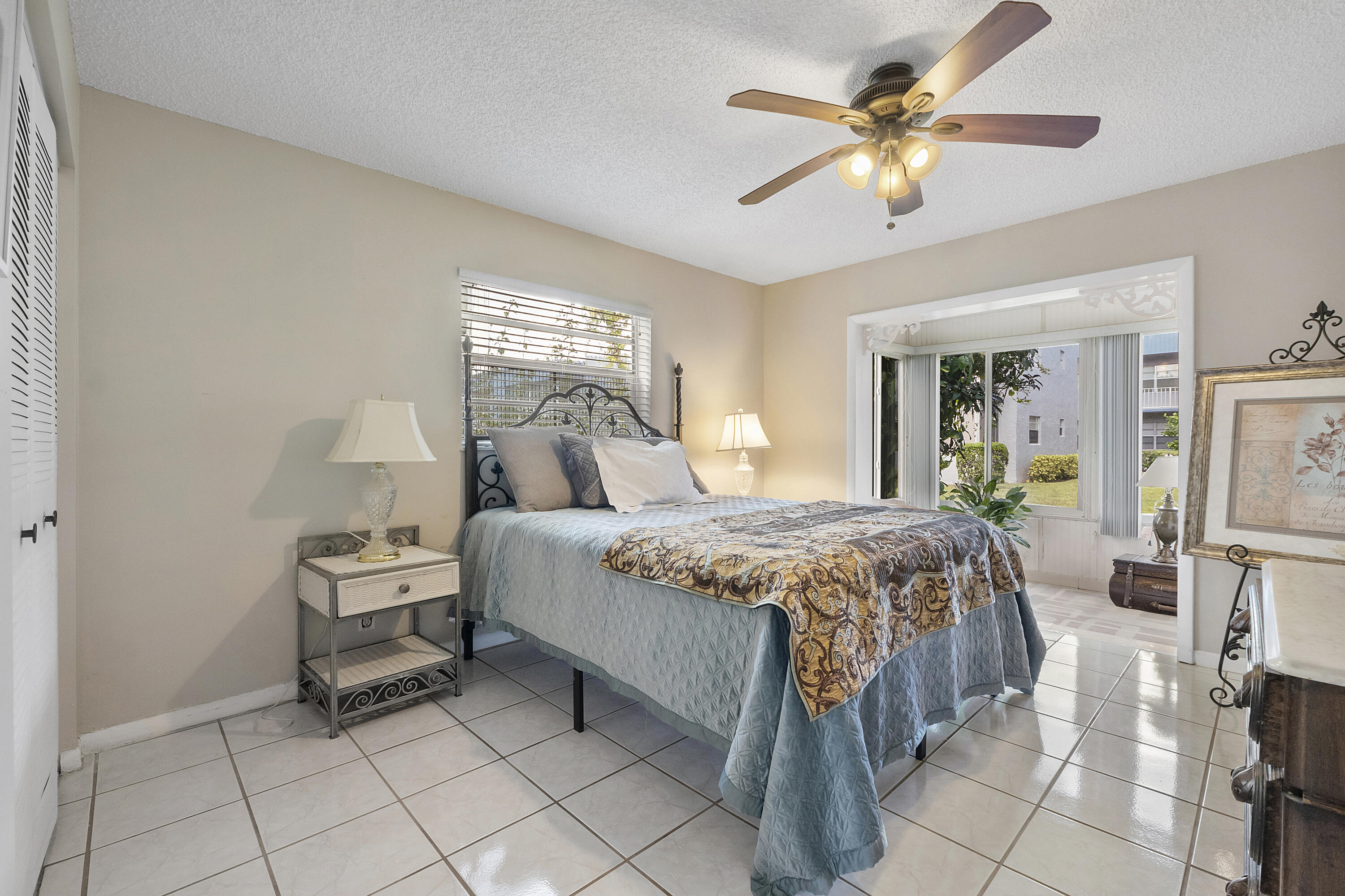 157 Flanders C Delray Beach, FL 33484 - Photo 18 of 45 a bedroom with a bed and a chandelier