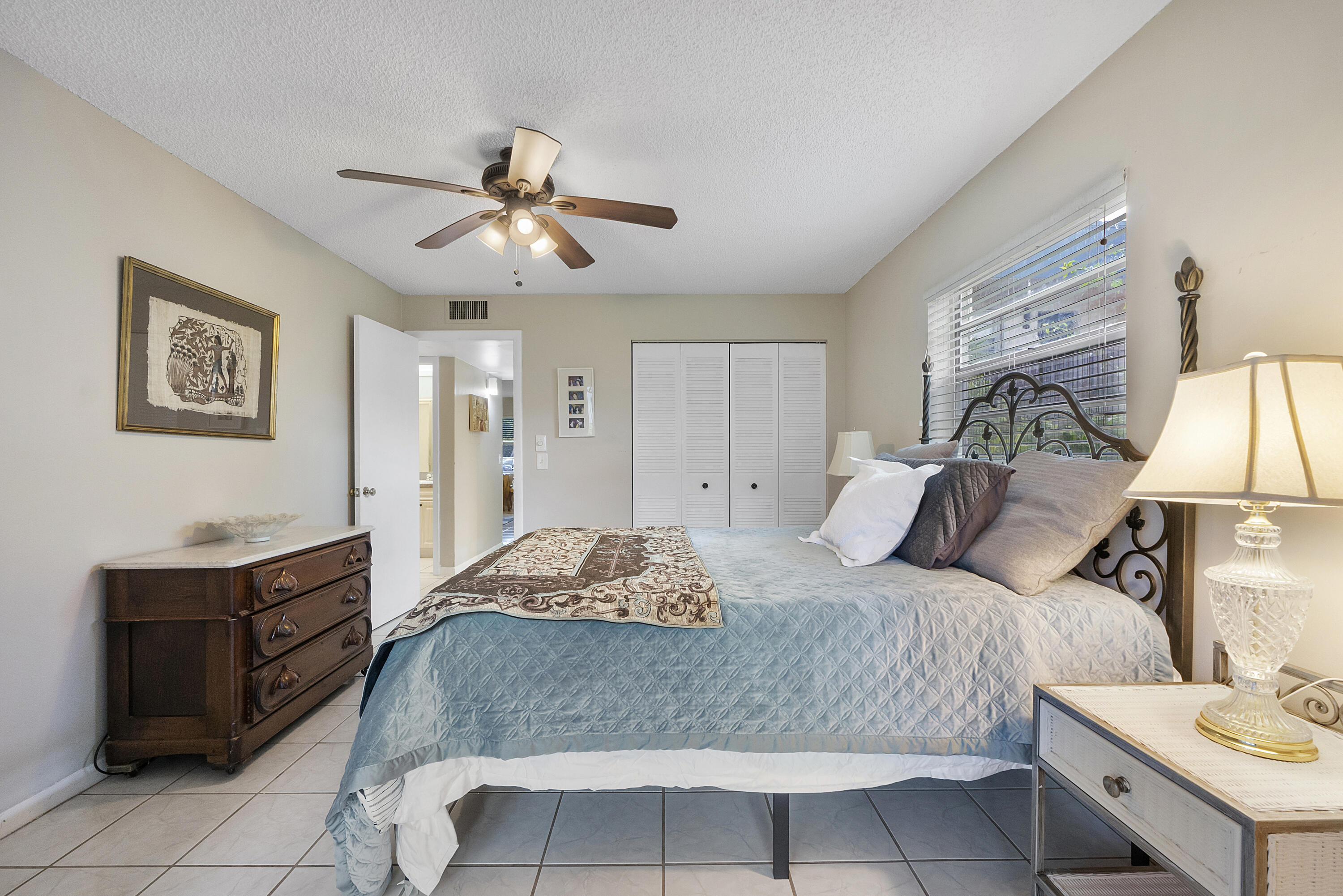 157 Flanders C Delray Beach, FL 33484 - Photo 19 of 45 a bedroom with a large bed and a chandelier