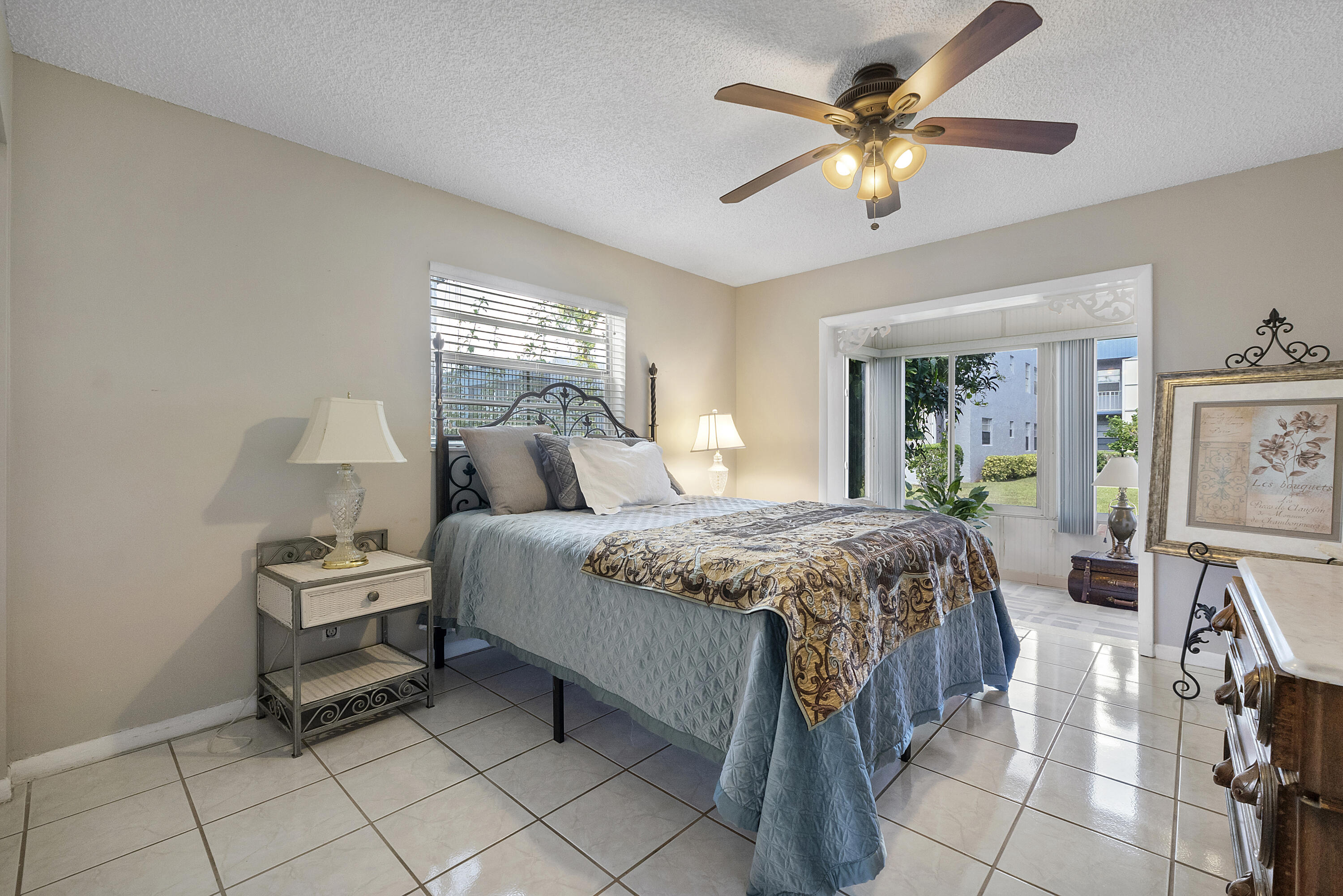 157 Flanders C Delray Beach, FL 33484 - Photo 20 of 45 a bedroom with a bed and a chandelier