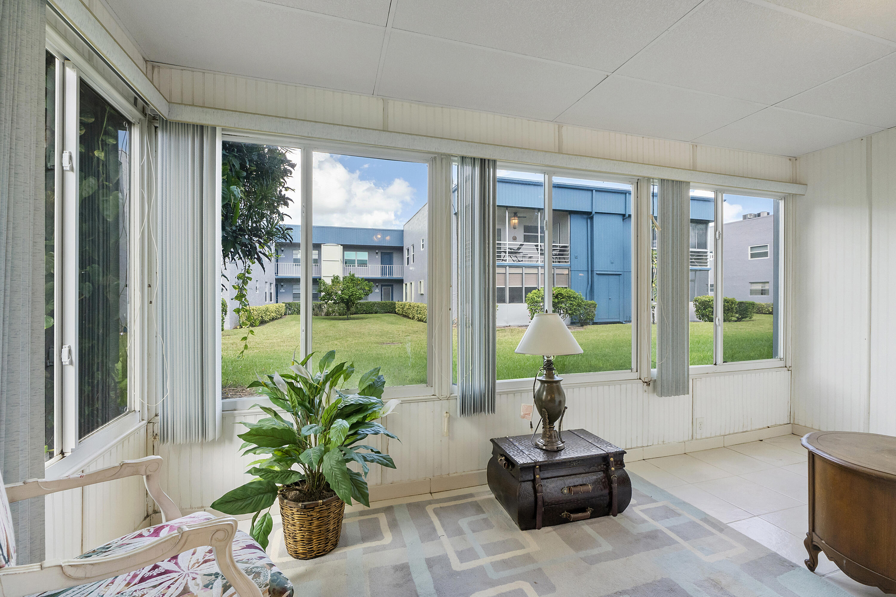 157 Flanders C Delray Beach, FL 33484 - Photo 25 of 45 a living room with furniture and a floor to ceiling window