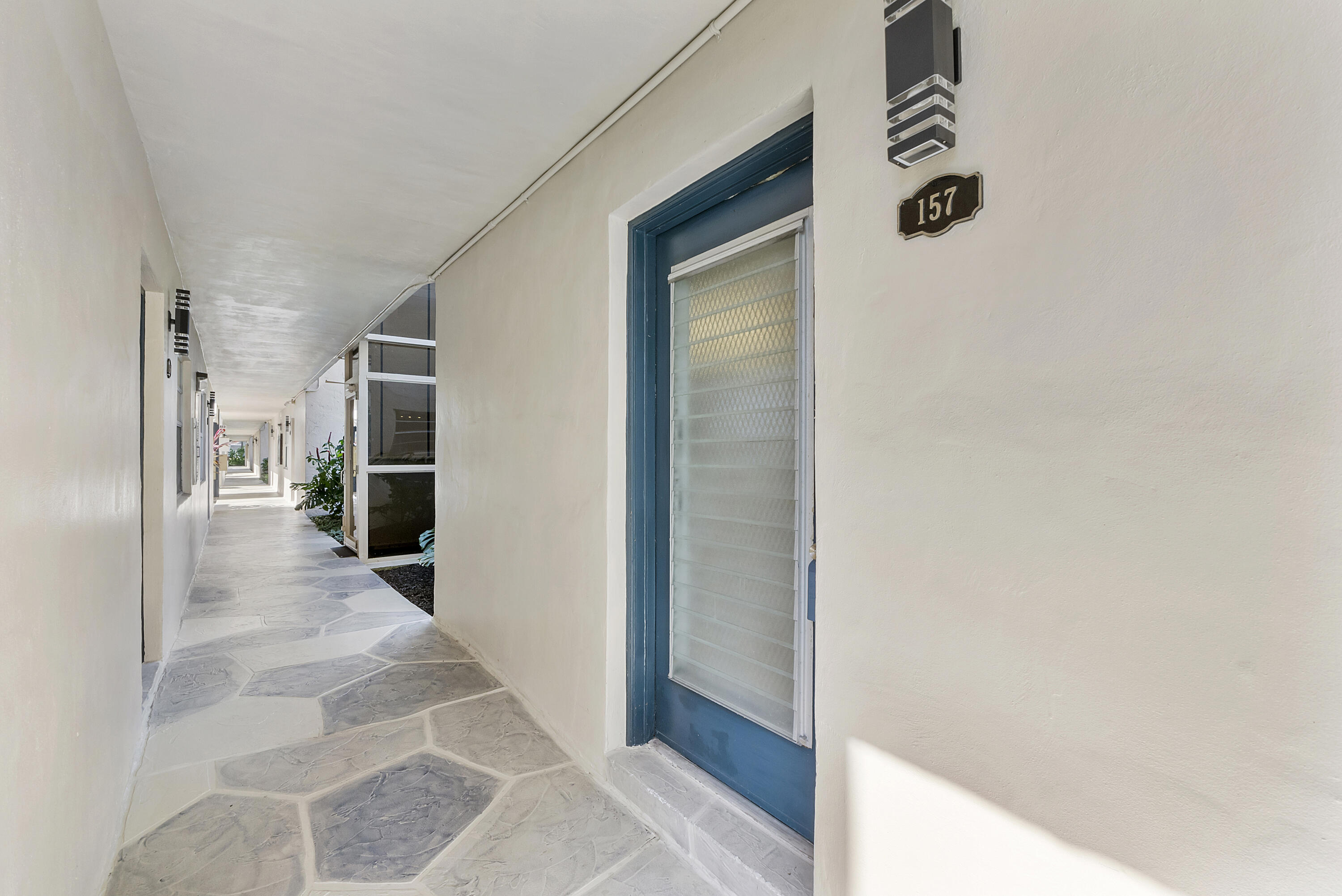 157 Flanders C Delray Beach, FL 33484 - Photo 27 of 45 a view of a hallway with wooden shelves