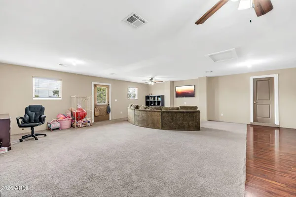 a bedroom with a bed a dresser and a chandelier