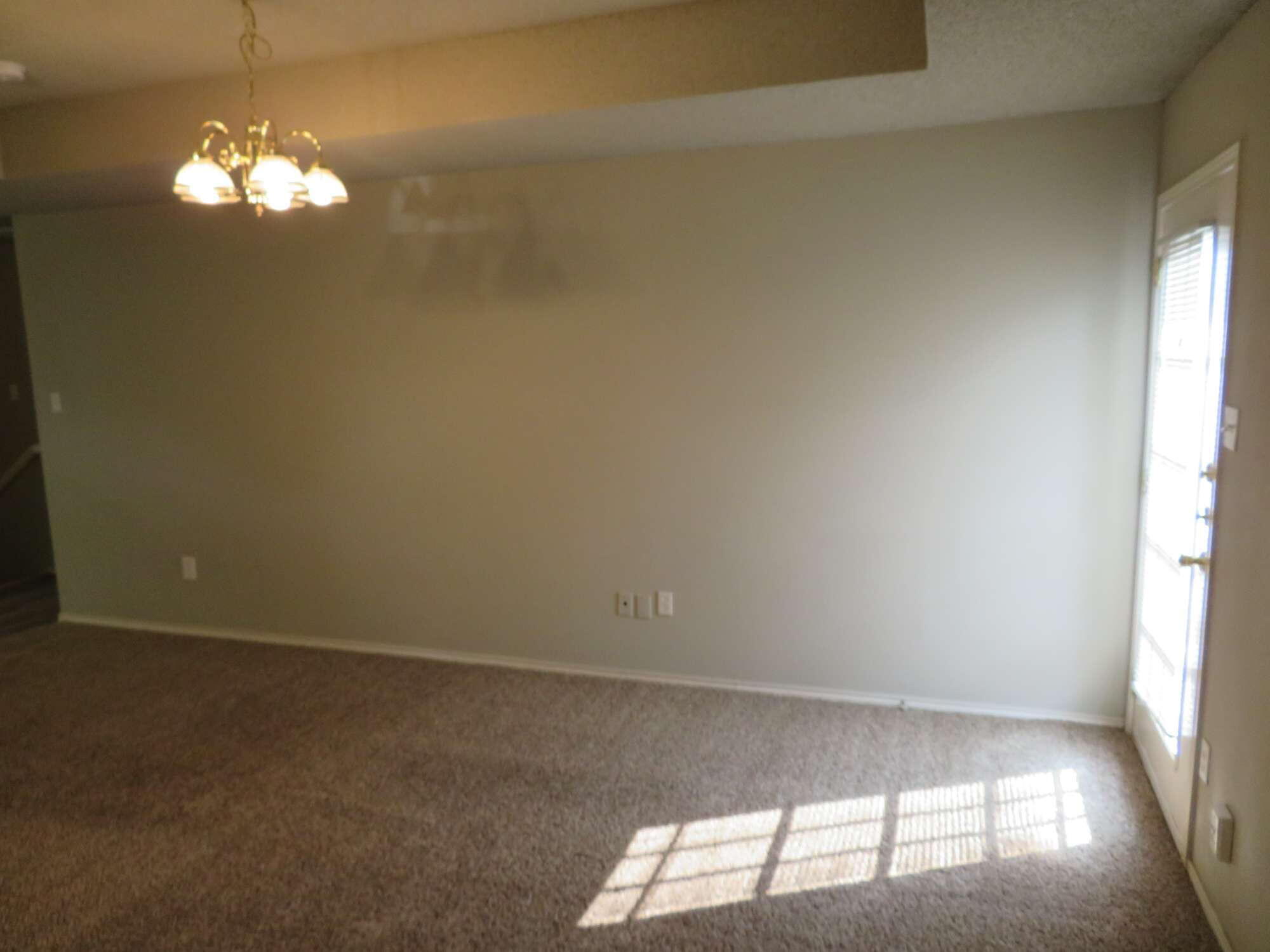 3403 97th Street Lubbock, TX 79423 - Photo 3 of 10 en empty room with windows and chandelier fan