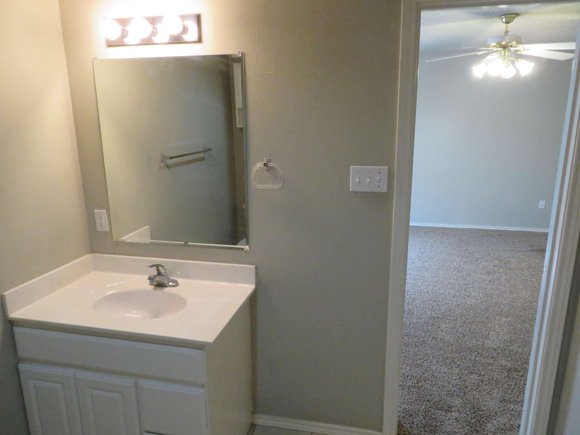 3403 97th Street Lubbock, TX 79423 - Photo 8 of 10 a bathroom with a sink and mirror