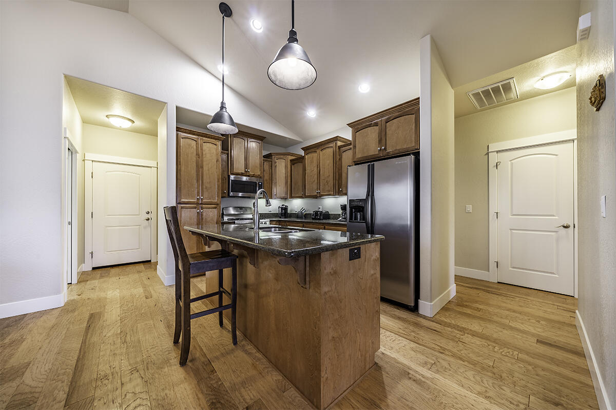 1078 North Haskell Street Central Point, OR 97502 - Photo 9 of 25 a kitchen with stainless steel appliances kitchen island granite countertop a refrigerator a stove and a wooden floors