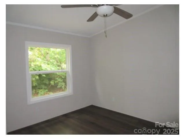 an empty room with a window and ceiling fan