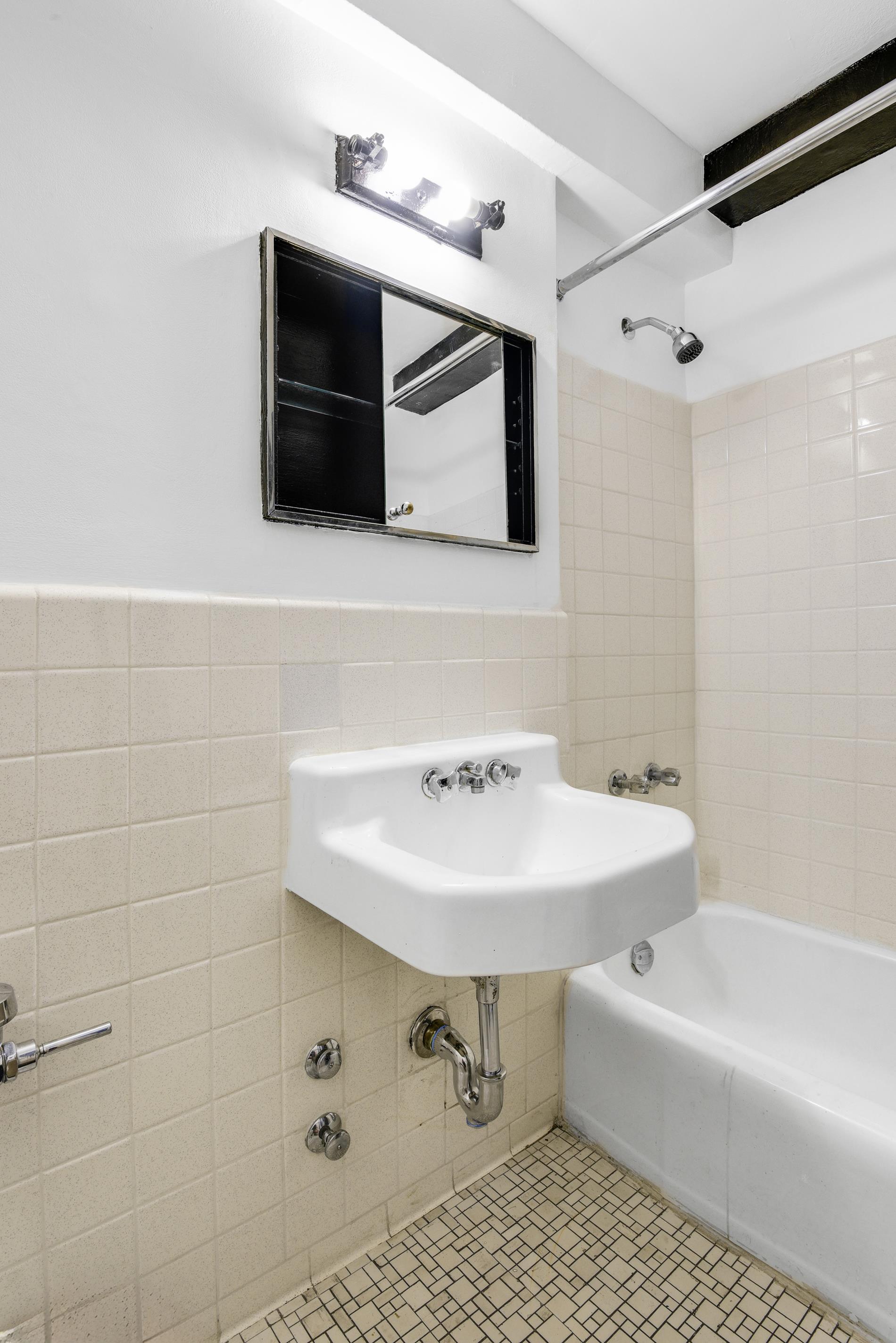 31 Jane Street, Unit 2H Manhattan, NY 10014 - Photo 7 of 10 a bathroom with a sink and a mirror