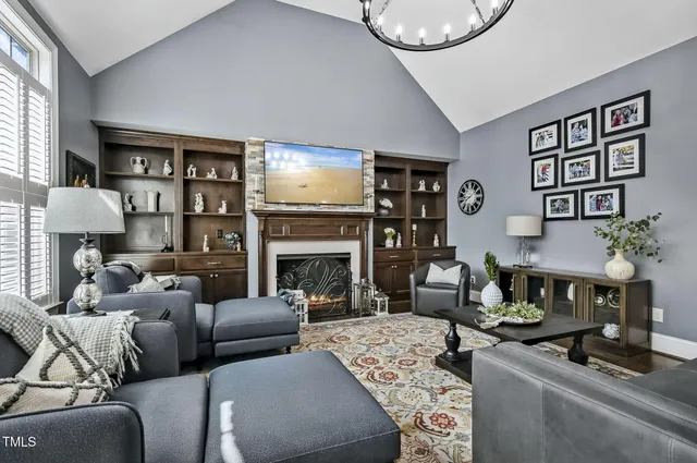 a living room with furniture a fireplace and a flat screen tv