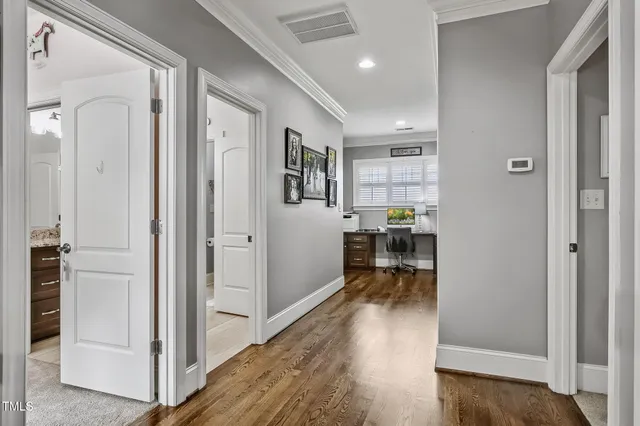 a view of a hallway with dining room and wooden floor