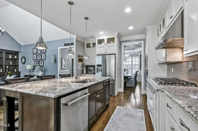 a kitchen with stainless steel appliances granite countertop a sink stove and refrigerator