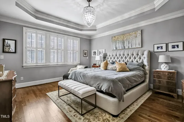 a spacious bedroom with a bed and wooden floor