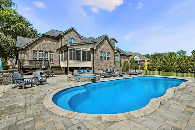 a view of a house with swimming pool and sitting area