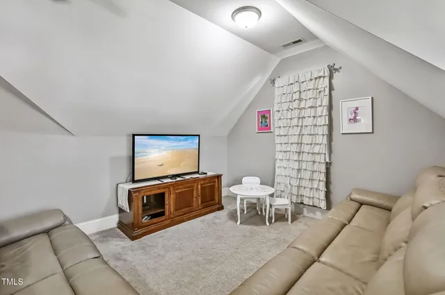 a living room with furniture a flat screen tv and a lamp