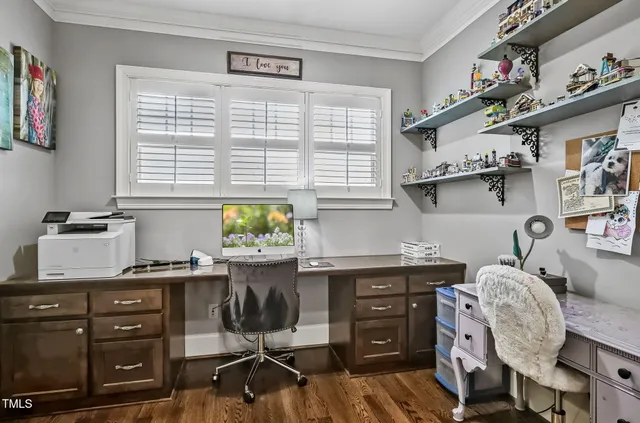 a view of a workspace with furniture and a window