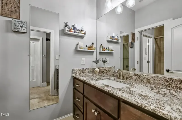 a bathroom with a granite countertop sink and a mirror
