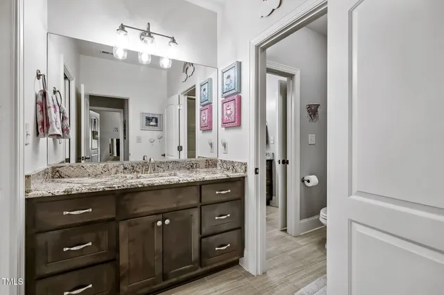a bathroom with a granite countertop sink vanity and mirror