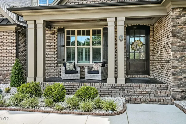 front view of of brick house with potted plants