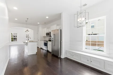 a kitchen with stainless steel appliances refrigerator oven and wooden floor