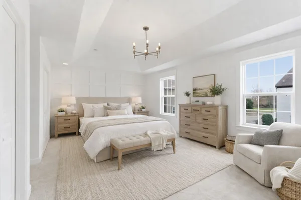 a bedroom with a bed couches and a view of kitchen