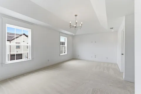 a view of a big room with windows and chandelier