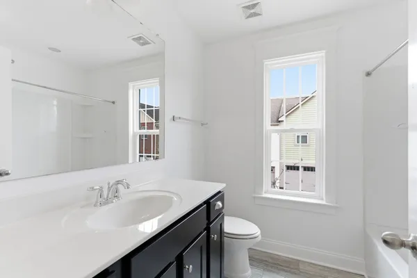 a bathroom with a sink toilet a mirror and shower