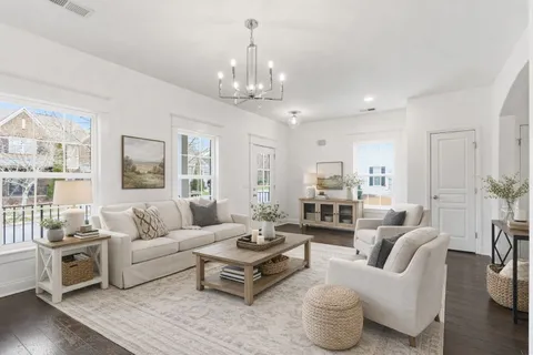 a living room with furniture wooden floor and a chandelier