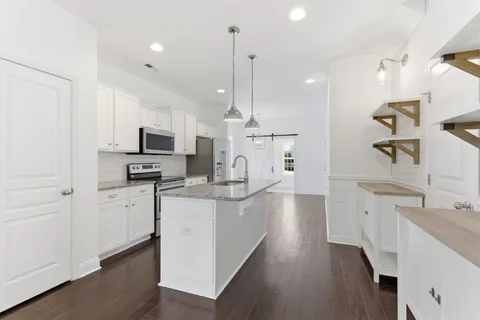 a large kitchen with white cabinets and stainless steel appliances