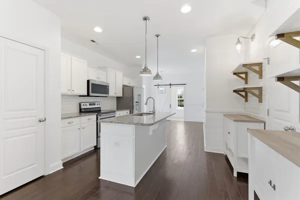 a large kitchen with white cabinets and stainless steel appliances