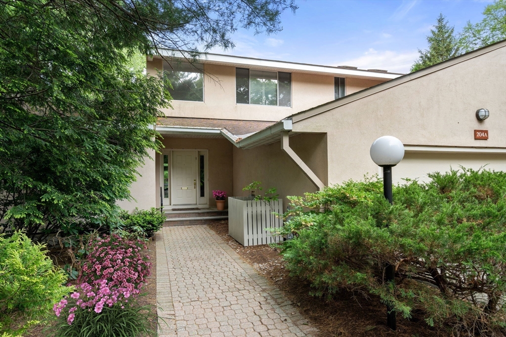 204 Allandale Road, Unit A Chestnut Hill, MA 02467 - Photo 1 of 19 a front view of a house with a yard and fountain