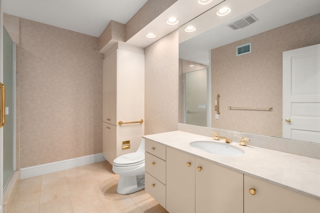 204 Allandale Road, Unit A Chestnut Hill, MA 02467 - Photo 9 of 19 a bathroom with a double vanity sink a toilet and a mirror