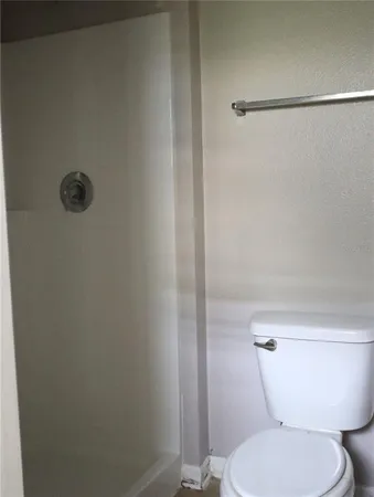 an empty room with wooden floor cabinet and windows