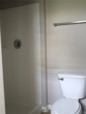 an empty room with wooden floor cabinet and windows