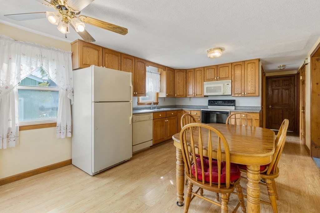 3 East Street Springfield, MA 01104 - Photo 2 of 29 a kitchen with stainless steel appliances a refrigerator a stove a dining table and chairs