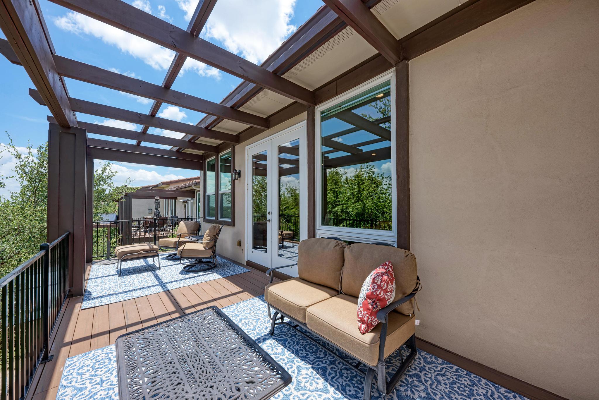 2601 North Quinlan Park Road, Unit 506 Austin, TX 78732 - Photo 33 of 39 An inviting outdoor living space features a covered patio with rich wood decking and an open pergola.