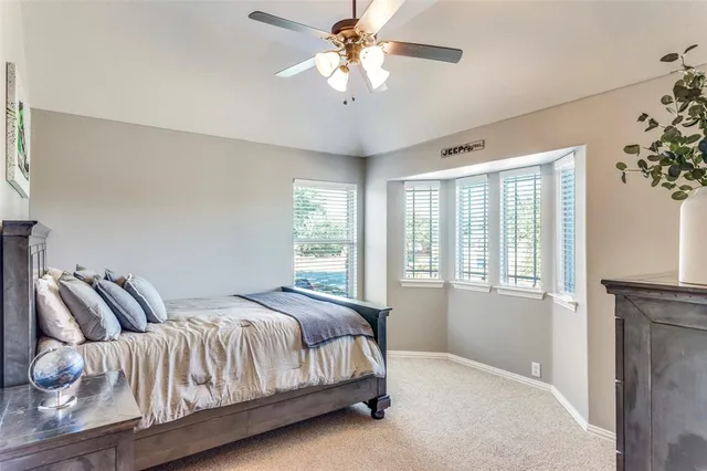 a bedroom with a large bed and a chandelier