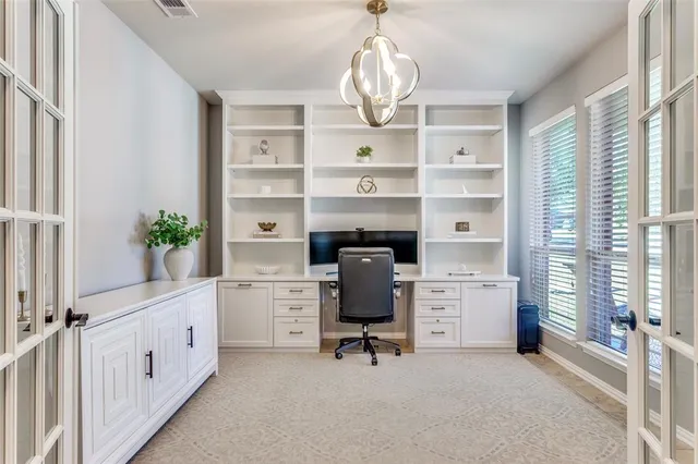 a view of a workspace with furniture and a window