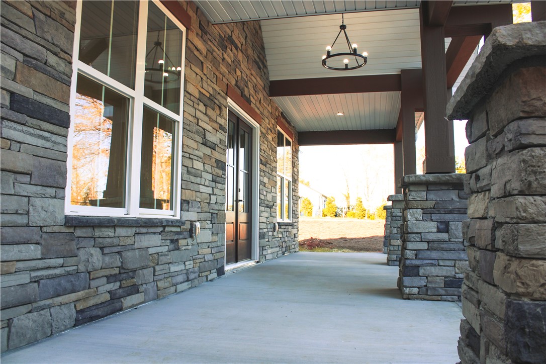 2515 Highway 29 Anderson, SC 29621 - Photo 36 of 38 A spacious covered front porch welcomes, showcasing substantial stone construction and warm wood accents.