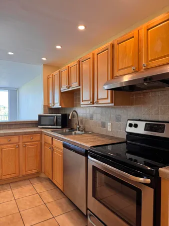 a kitchen with granite countertop a sink and cabinets
