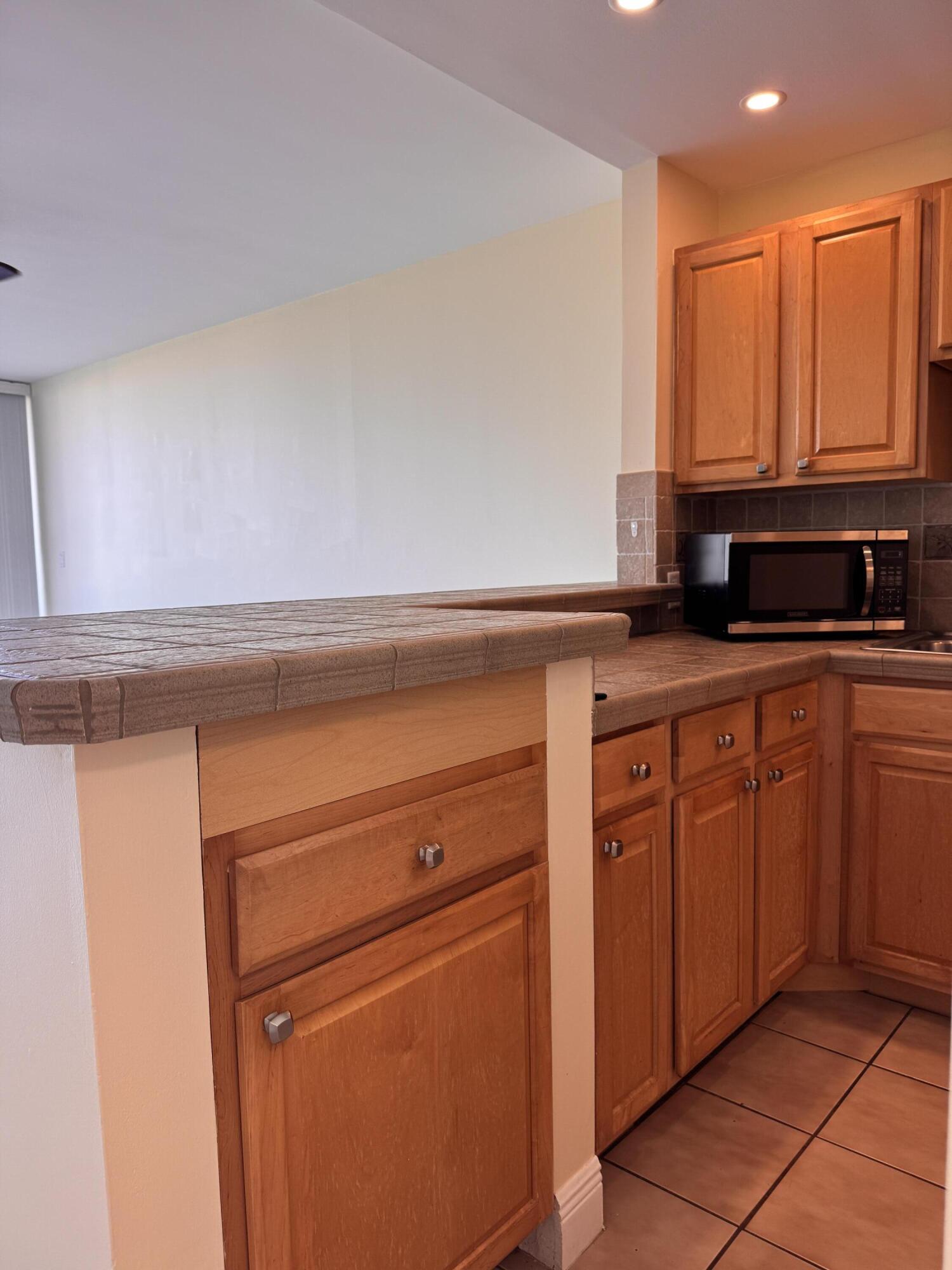 88540 Overseas Highway, Unit 203 Tavernier, FL 33070 - Photo 19 of 35 a kitchen with granite countertop a sink and cabinets