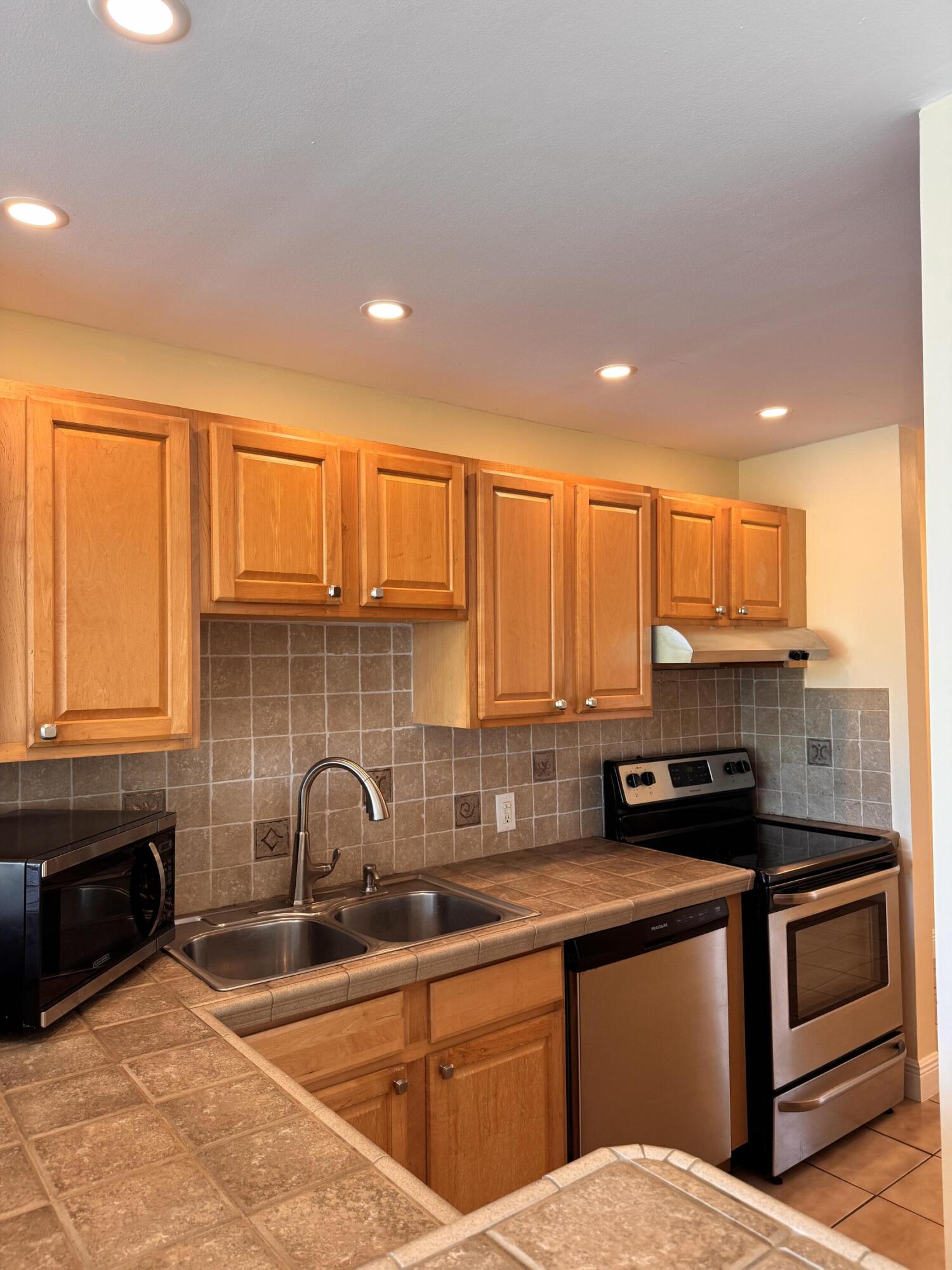 88540 Overseas Highway, Unit 203 Tavernier, FL 33070 - Photo 2 of 35 a kitchen with stainless steel appliances a sink stove and cabinets