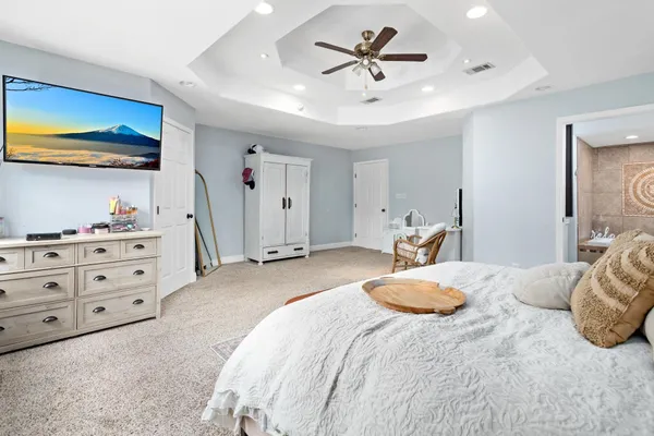 a bedroom with a large bed and a flat tv screen