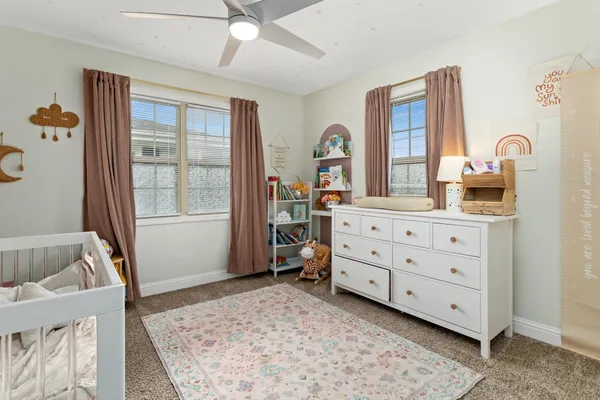 a bathroom with a granite countertop toilet a sink a mirror and a window