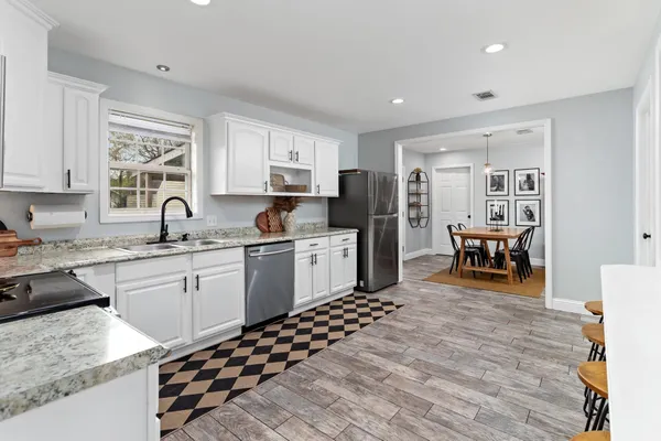 a kitchen with granite countertop a refrigerator and a sink