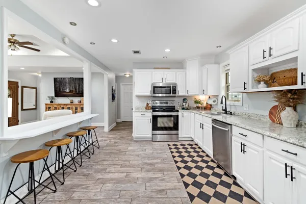 a large kitchen with stainless steel appliances lots of counter space and wooden floor