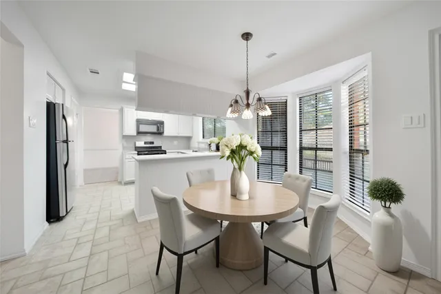 a view of a dining room and chandelier furniture and kitchen view